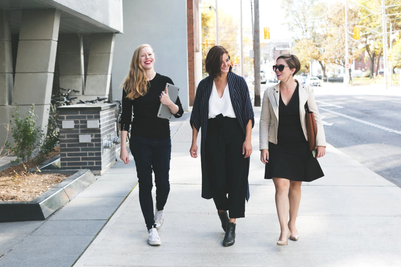 Three business professionals walking together on a city sidewalk